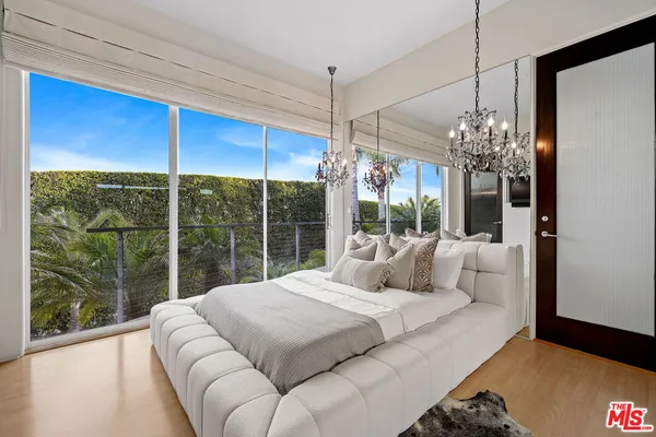 a bedroom with furniture and a large window