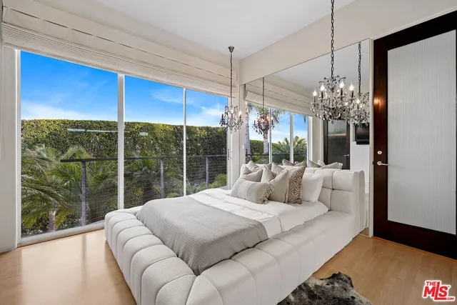 a bedroom with furniture and a large window