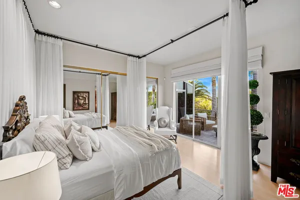 a bedroom with a bed and a large mirror