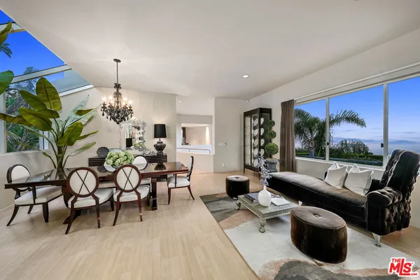 a living room with furniture a lamp and a floor to ceiling window