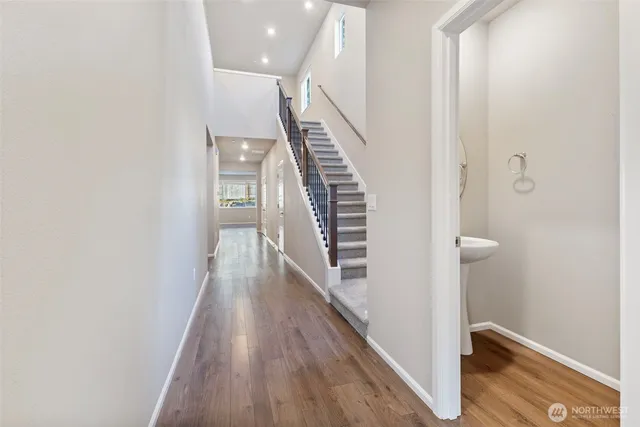a view of a hallway with wooden floor and staircase