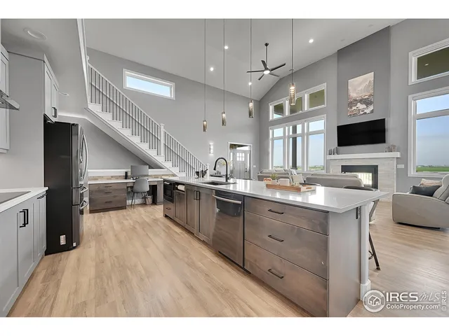 a open kitchen with stainless steel appliances kitchen island granite countertop a table chairs and a refrigerator