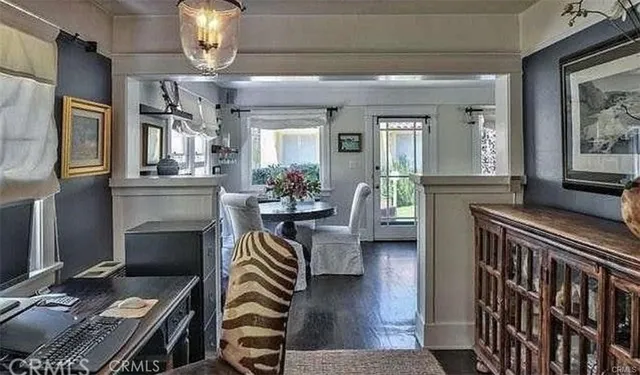 a dining room with furniture a chandelier and wooden floor