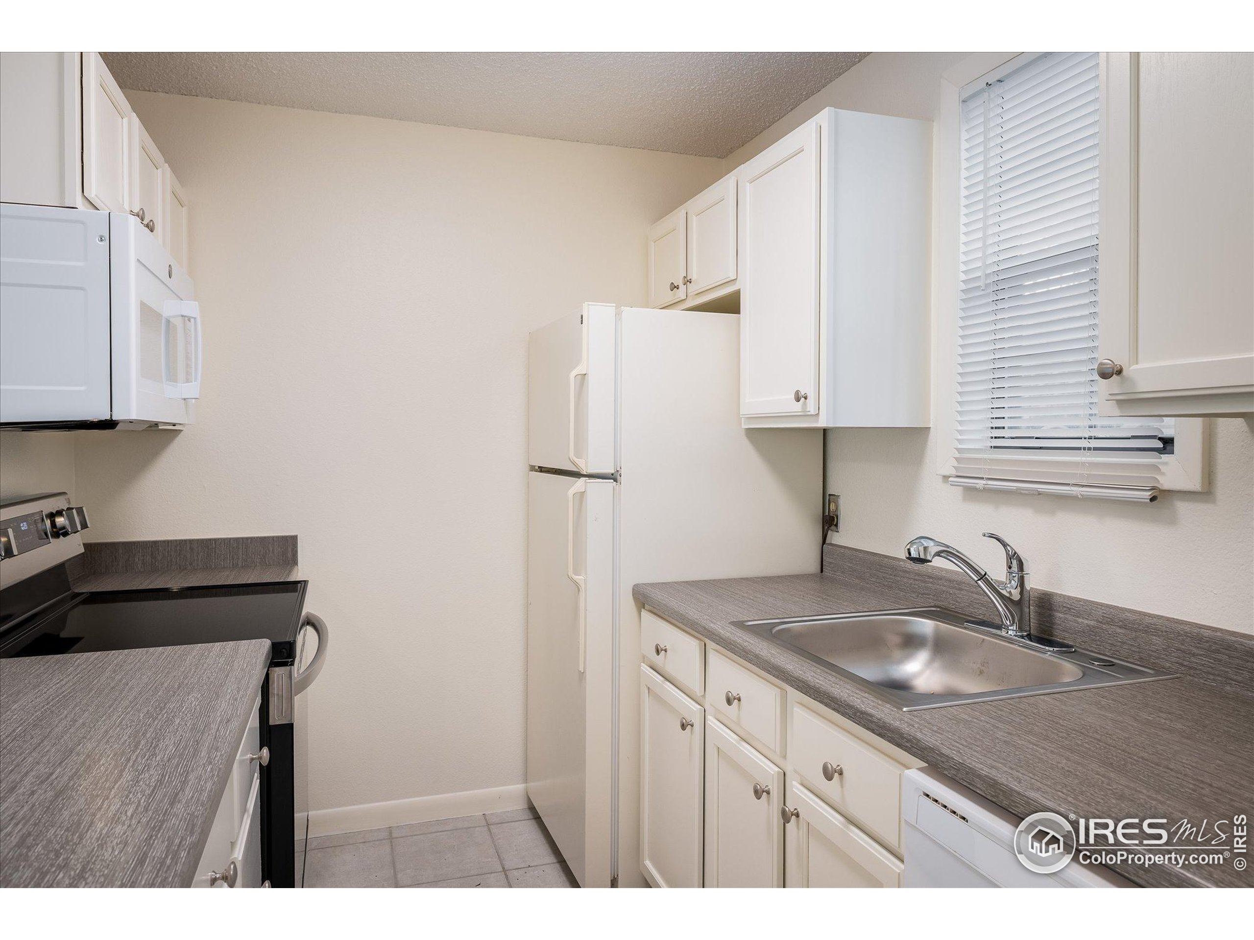 3000 Colorado Avenue, Unit 122 Boulder, CO 80303 - Photo 11 of 31 a kitchen with kitchen island a sink stove and refrigerator