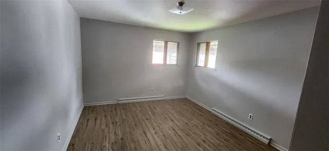 an empty room with wooden floor and a window