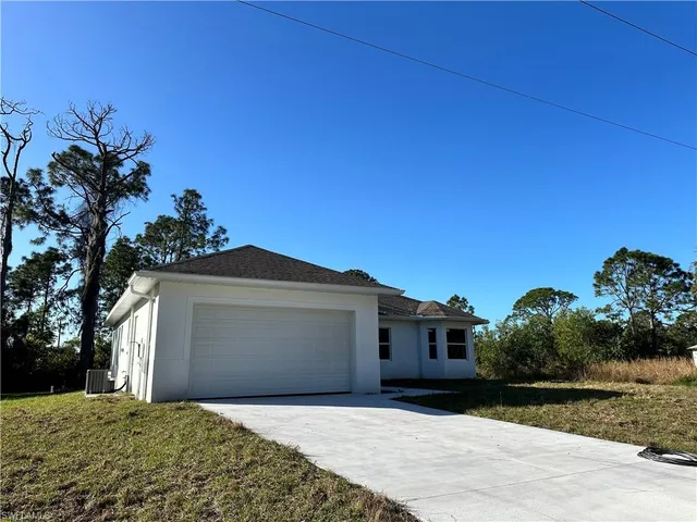 a front view of a house with a garden and yard