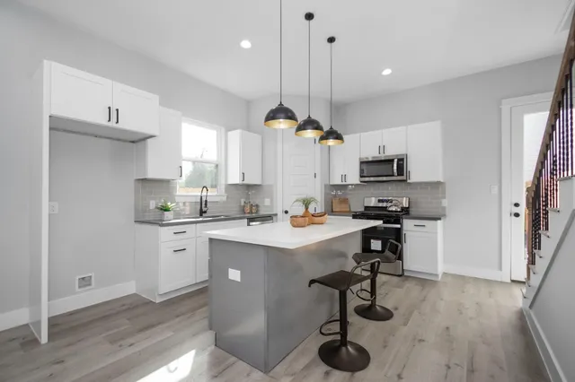 a kitchen with kitchen island a sink a stove a center island stainless steel appliances and cabinets