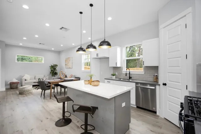 a kitchen with a table chairs sink and cabinets