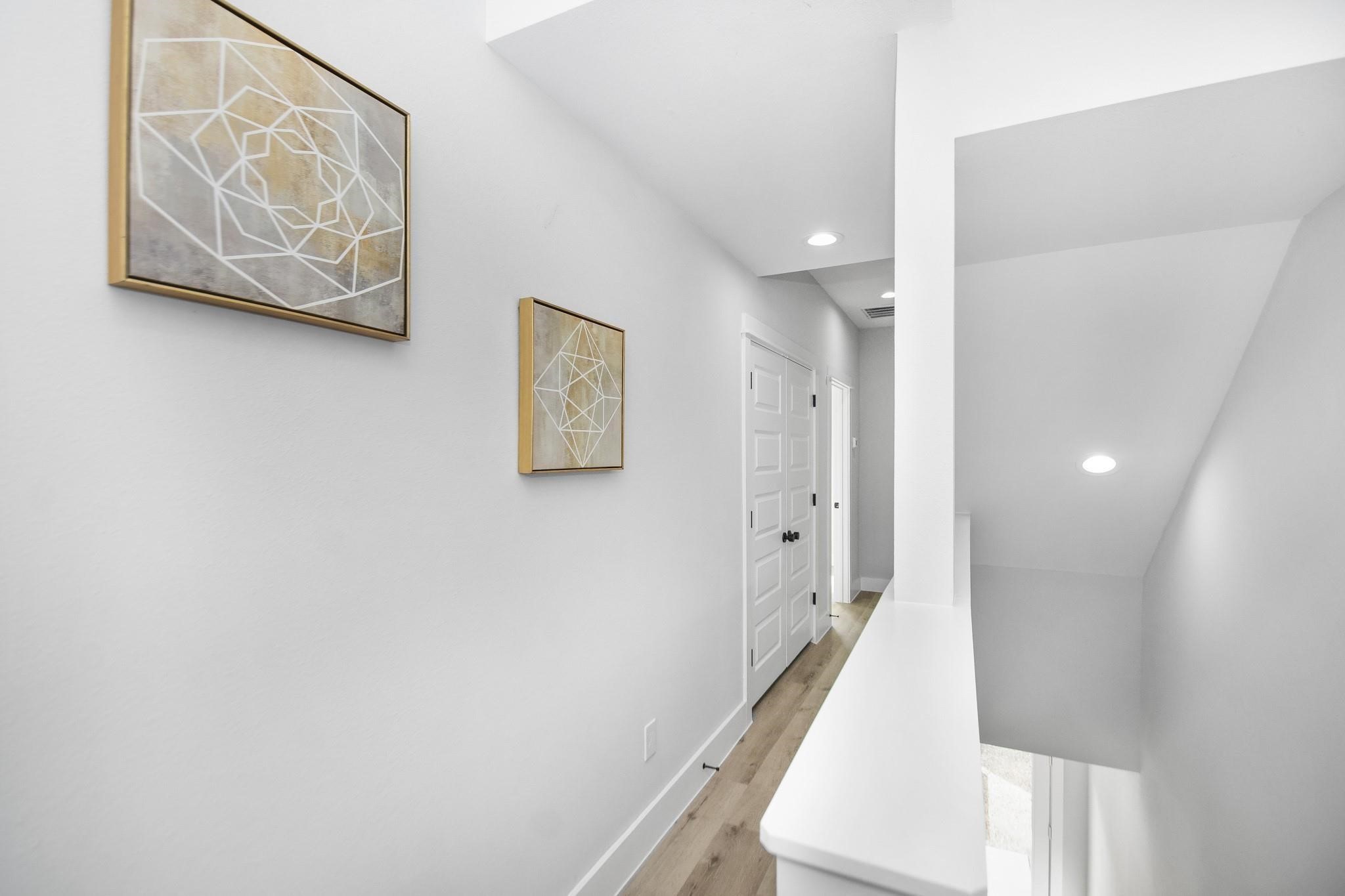 2105 Sam Wilson Street, Unit A Houston, TX 77020 - Photo 7 of 22 a view of a hallway with paintings on the wall