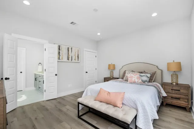 a bedroom with a bed and wooden floor