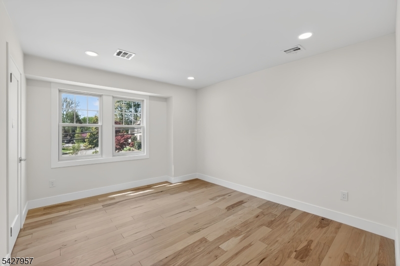 909 Ridgewood Road Millburn, NJ 07041 - Photo 17 of 33 wooden floor in an empty room with a window