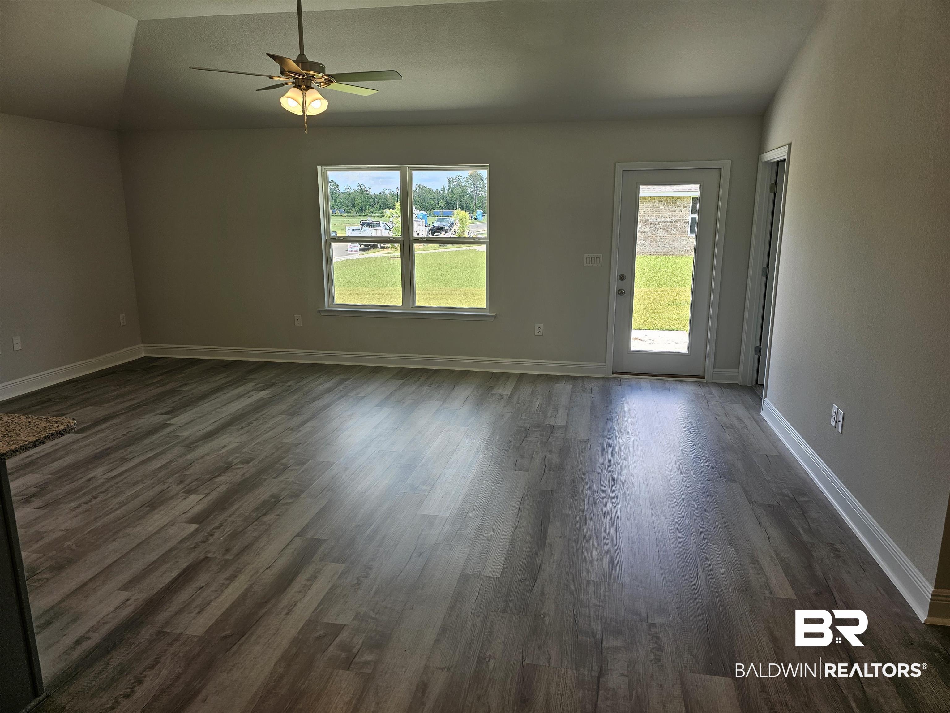 1412 Plymouth Drive Foley, AL 36535 - Photo 6 of 10 Empty room featuring dark wood-type flooring, ceiling fan, and lofted ceiling