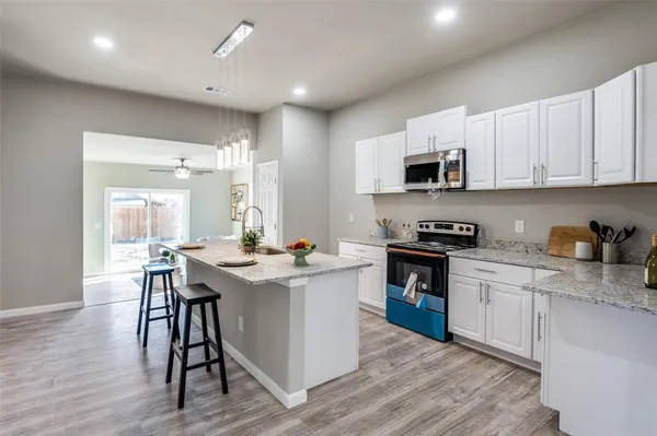 a kitchen with a sink cabinets and wooden floor