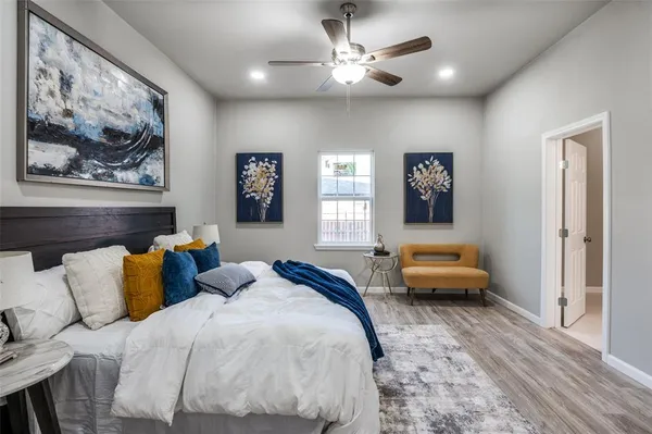 a bedroom with a bed couches and painting on the wall