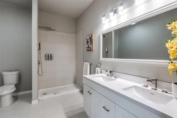 a bathroom with a double vanity sink toilet and shower