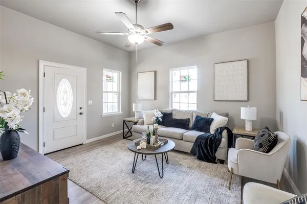 a living room with furniture a chandelier and a window