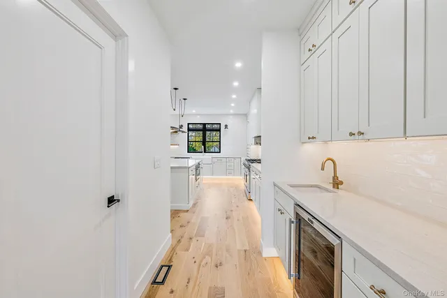 a view of a kitchen with wooden floor and electronic appliances
