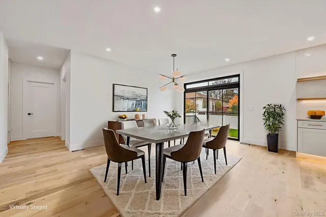 a kitchen with granite countertop a sink dishwasher stove and white cabinets with wooden floor