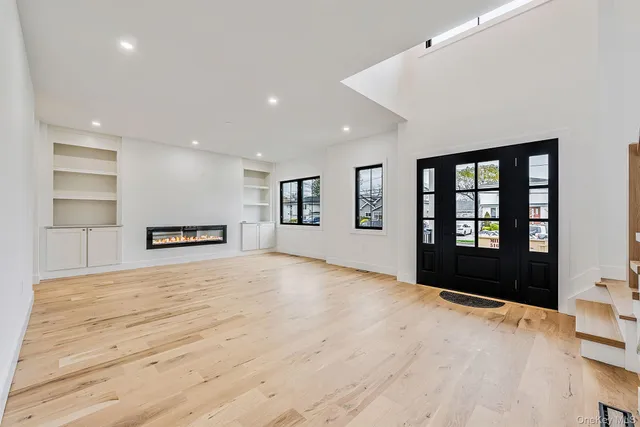 a view of an empty room with a window and fireplace