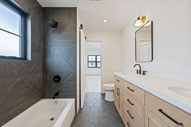 a bathroom with a sink and mirror with toilet