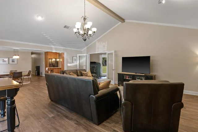 a living room with furniture a flat screen tv and kitchen view