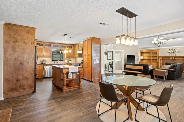 a kitchen with stainless steel appliances a dining table chairs and couches