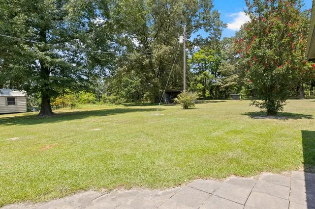 a view of yard with swimming pool and green space