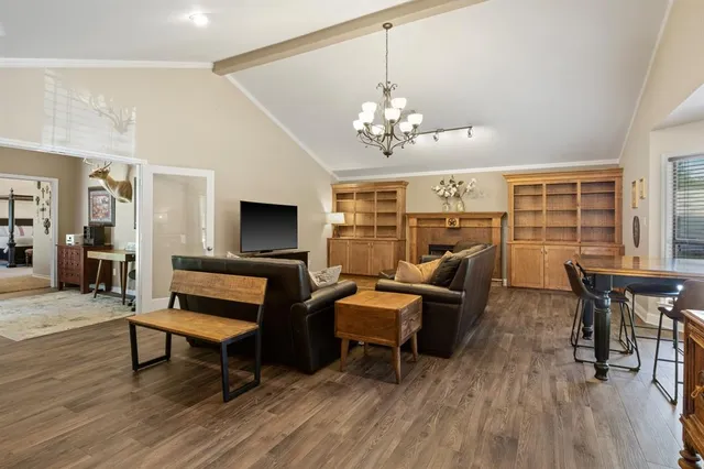 a living room with furniture flat screen tv and wooden floor