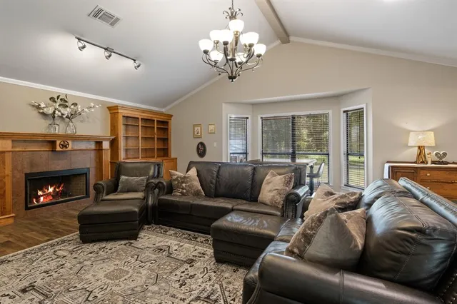 a living room with furniture a fireplace and a chandelier