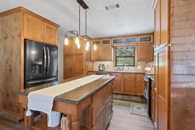 a kitchen that has a lot of cabinets and a wooden floor