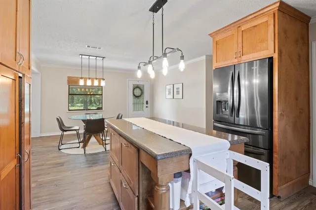 a kitchen with granite countertop a stove a refrigerator and wooden floor