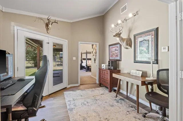 a view of a bedroom with workspace and windows