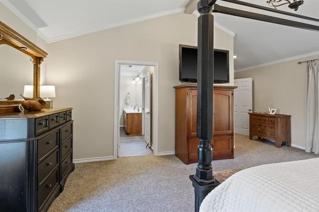 a bedroom with a bed and a tv on the dresser
