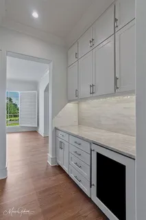 a view of an empty room with a kitchen and a window