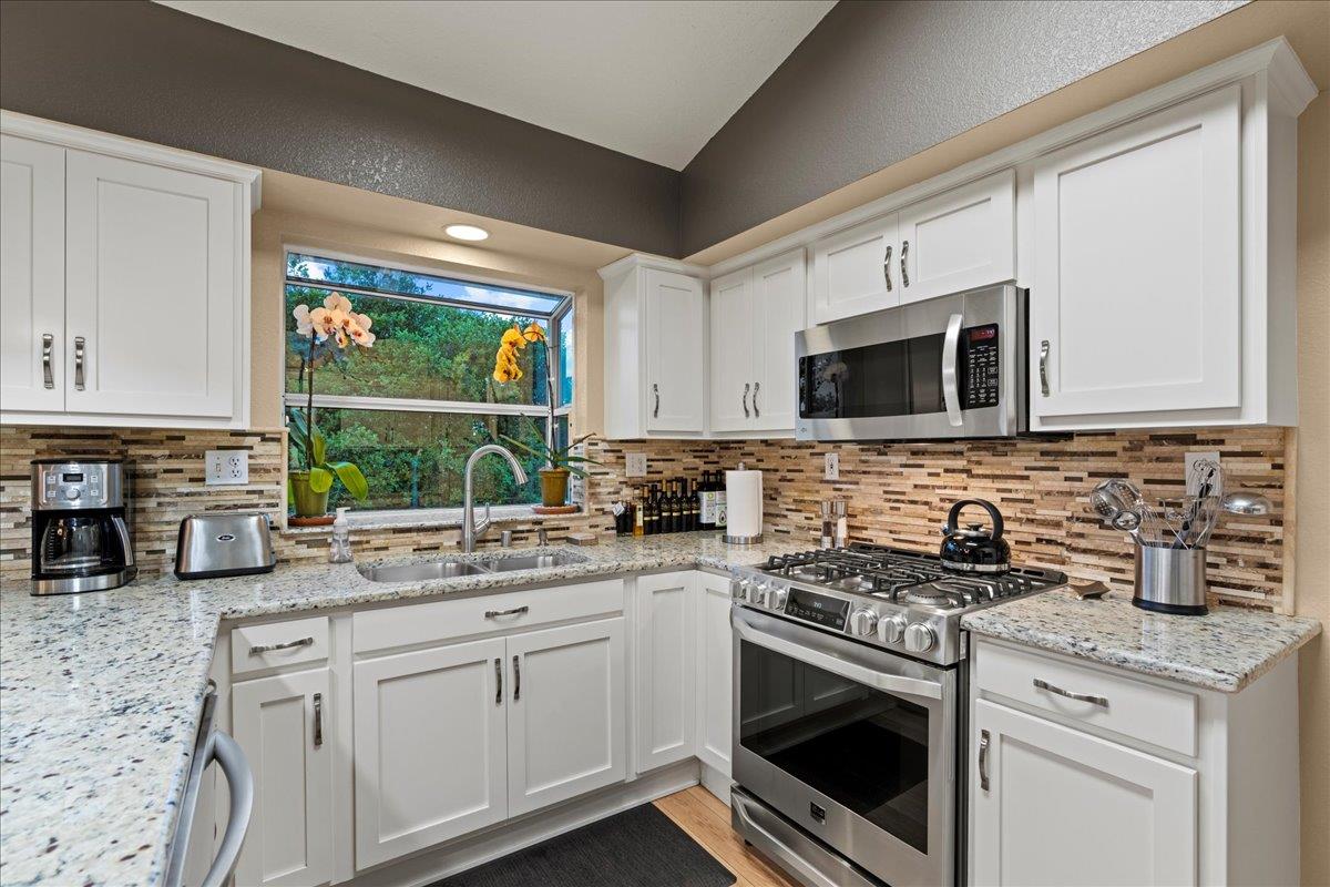 6980 Timeview Way Prunedale, CA 93907 - Photo 9 of 47 a kitchen with stainless steel appliances granite countertop a stove a microwave and sink