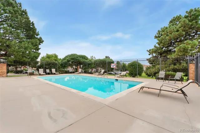 a view of swimming pool with seating area and trees