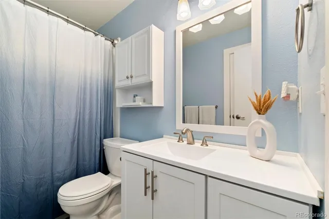 a bathroom with a sink a toilet and shower curtain