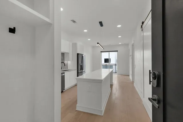 a view of a kitchen with refrigerator and windows