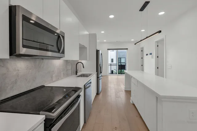 a kitchen with stainless steel appliances granite countertop a sink and a stove