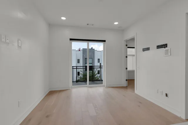 a view of a big room with wooden floor and a bathroom