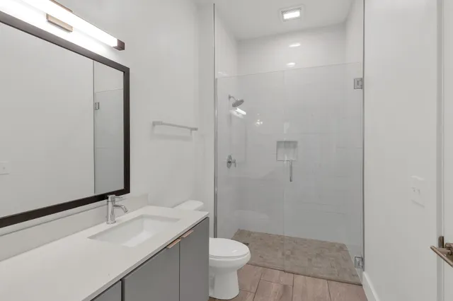 a bathroom with a sink a toilet and shower