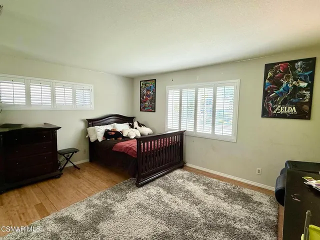 a bedroom with a bed window and wall painting
