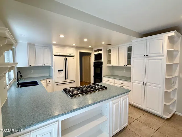 a kitchen with a refrigerator a stove a microwave and cabinets