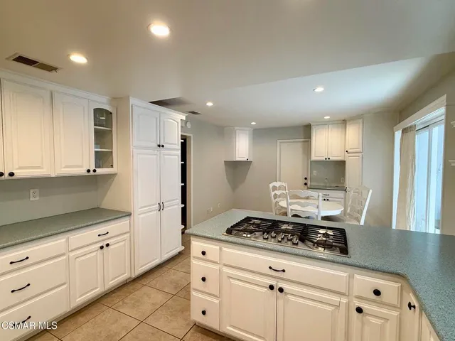a kitchen with white cabinets and appliances