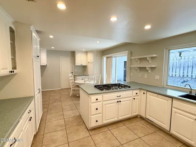 a kitchen with granite countertop a sink stove and cabinets