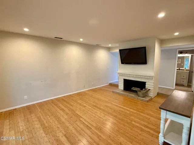a view of empty room with a flat screen tv and fireplace