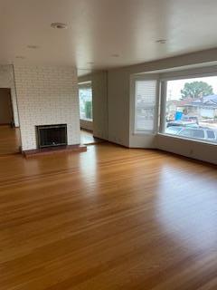 869 Crestview Drive Millbrae, CA 94030 - Photo 2 of 14 a view of empty room with wooden floor and fireplace
