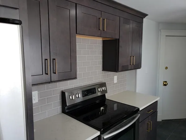 a kitchen with granite countertop a stove and a microwave