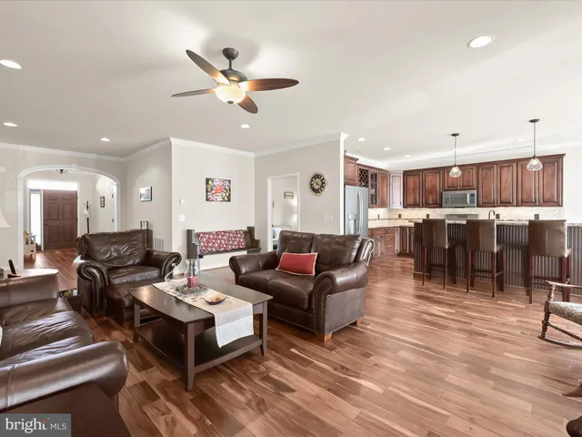 a living room with furniture kitchen view and a chandelier