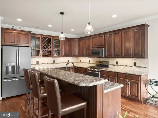 a kitchen with granite countertop a sink stainless steel appliances and cabinets